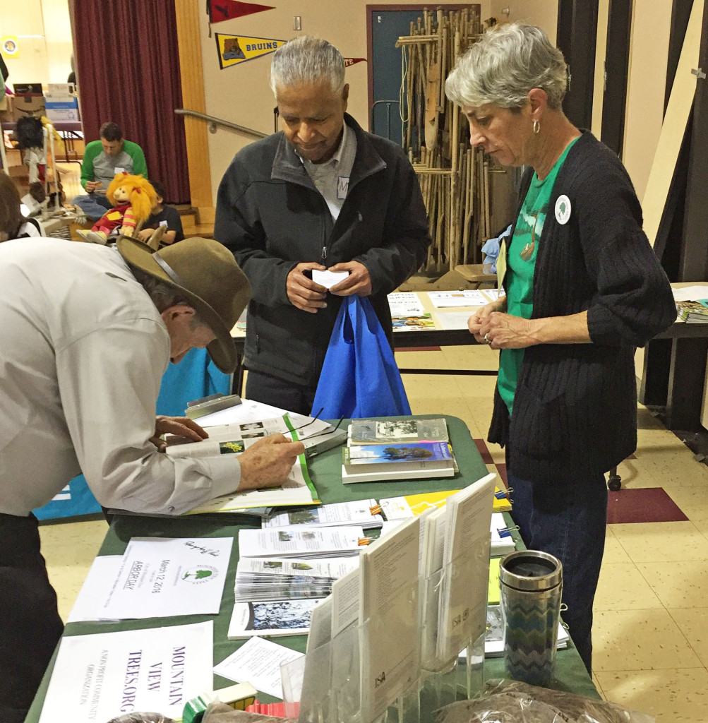 Ray Morneau (bending down) and Susan Hamilton brought information from Mountain View Trees.